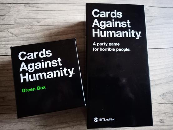 Zwei schwarze Boxen mit der weißen Aufschrift "Cards against humanity".