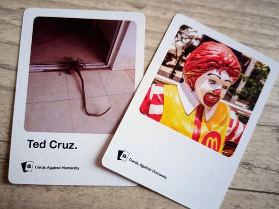 Zwei der Fotoantwortkarten. Die eine zeigt Ronald McDonald. Die andere eine widerliche Spinne. Darunter steht "Ted Cruz".